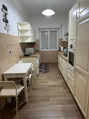 a kitchen with white appliances and a table and chairs at Roma nel Mondo in Rome