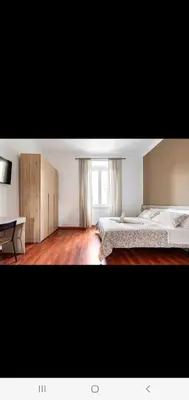 a large bedroom with two beds and a desk at Cuore Di Roma Holidays in Rome