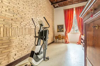 a room with a brick wall and an exercise bike at iFlat Pantheon Elegant 3-bedroom Apartment in Rome