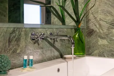 a bathroom sink with a faucet and a vase at iFlat Pantheon Elegant 3-bedroom Apartment in Rome