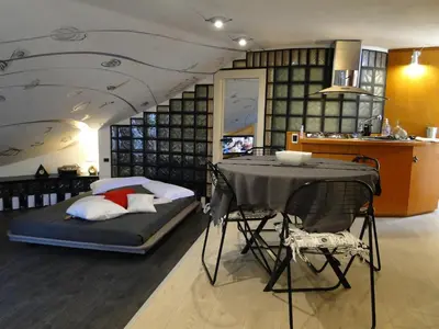 a bedroom with a bed and a table and a kitchen at Jazz Style Home in Rome