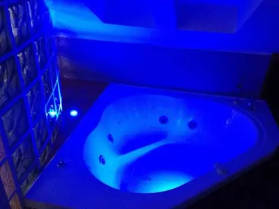 a bath tub in a room with a blue light at Jazz Style Home in Rome