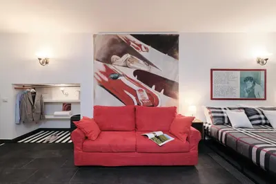 a living room with a red couch and a bed at Casa Calligarich Stadio Olimpico Foro Italico in Rome