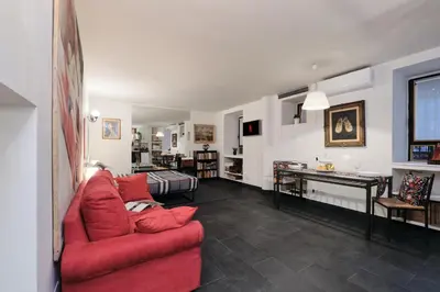 a living room with a red couch and a table at Casa Calligarich Stadio Olimpico Foro Italico in Rome