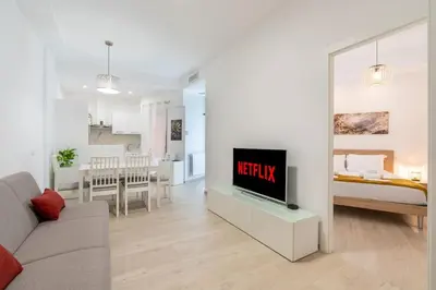 a living room with a couch and a tv on a table at Metro A 1 min - Casa Elegante - 3 bagni En Suite in Rome