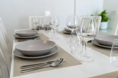 a table with plates and wine glasses on it at Metro A 1 min - Casa Elegante - 3 bagni En Suite in Rome
