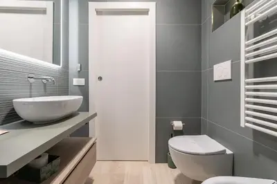 a bathroom with a white sink and a toilet at Metro A 1 min - Casa Elegante - 3 bagni En Suite in Rome