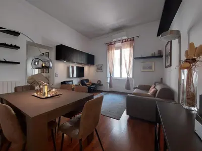 a kitchen and living room with a table and chairs at Nel cuore del Vaticano spazioso ed elegante in Rome