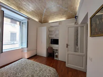 a bedroom with a bed and a window and a door at Nel cuore del Vaticano spazioso ed elegante in Rome