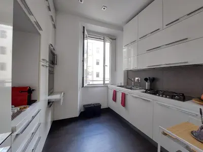 a kitchen with white cabinets and a large window at Nel cuore del Vaticano spazioso ed elegante in Rome