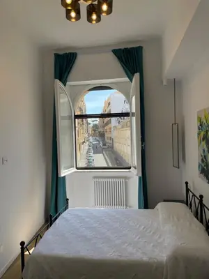 a bedroom with a bed and a large window at a casa di Manuela luxury apartment in Rome