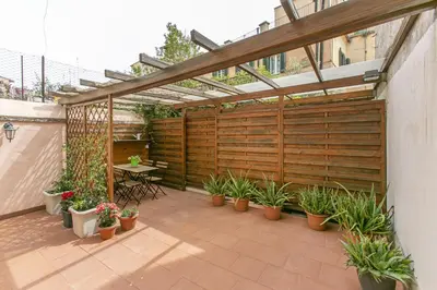 a patio with potted plants and a wooden pergola at C M La Terrasse di Monti in Rome