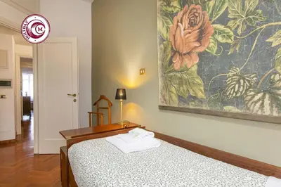 a bedroom with two beds and a painting on the wall at C M La Terrasse di Monti in Rome