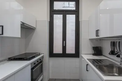 a white kitchen with a sink and a window at Vittoria Urban Chic - elegant apartment in the heart of Rome in Rome