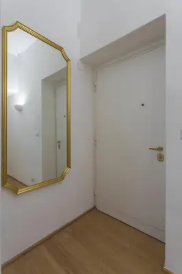 a mirror on a wall next to a door at Vittoria Urban Chic - elegant apartment in the heart of Rome in Rome