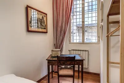 a bedroom with a table and a window and a bed at Domus in Via Del Corso in Rome