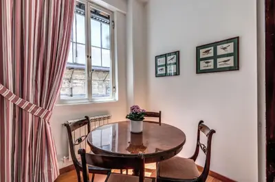 a dining room with a table and chairs and a window at Domus in Via Del Corso in Rome