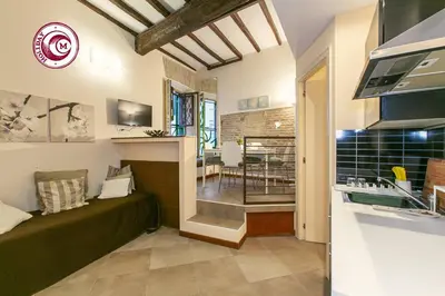 a living room with a green couch and a kitchen at C M Via Veneto Sweet Apartment in Rome