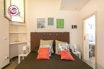 a bedroom with a large bed with orange pillows at C M Via Veneto Sweet Apartment in Rome