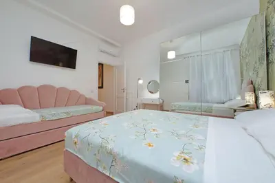 a bedroom with two beds and a tv on the wall at Appia Holiday Home in Rome