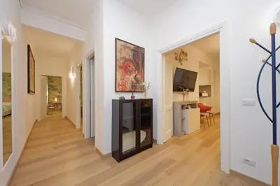 a living room with white walls and a hard wood floor at Appia Holiday Home in Rome