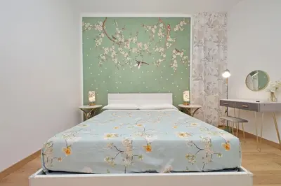 a bedroom with a bed with a painting on the wall at Appia Holiday Home in Rome
