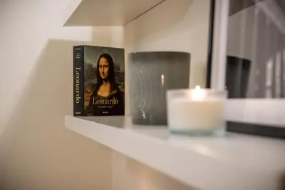 a book sitting on a shelf next to a candle at La Chiostrina al Vaticano in Rome