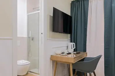 a bathroom with a desk and a toilet and a television at Risorgimento 9 - Guest House in Rome