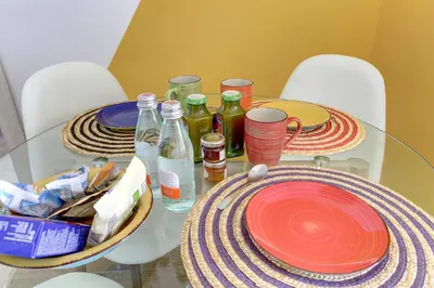 a glass table with plates and bottles on it at Furio Camillo Studio - Metro A - Netflix in Rome
