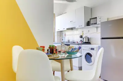 a kitchen with a table and a washing machine at Furio Camillo Studio - Metro A - Netflix in Rome