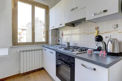 a kitchen with a stove top oven next to a window at Furio Camillo Studio - Metro A - Netflix in Rome