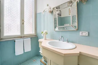 a bathroom with a sink and a mirror at Casa Tudor, Charmy Eccentric Flat in Piccola Londra 10 Min from City Center in Rome