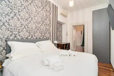 a bedroom with a white bed with white towels on it at OLEUM Roma Veneto in Rome
