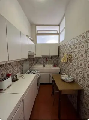 a kitchen with white appliances and a wooden table at Maison Leone IV 22 in Rome
