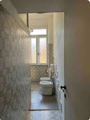 a bathroom with a toilet and a window at Maison Leone IV 22 in Rome