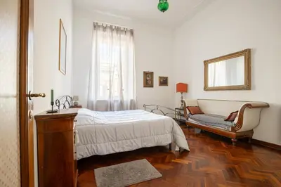 a bedroom with a bed and a chair and a window at Rome Historic Center Stylehouse in Rome