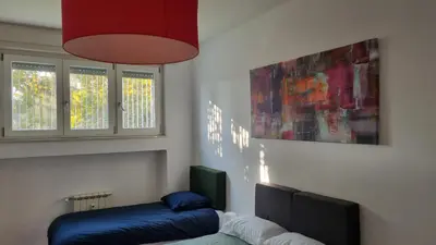 a living room with a blue couch and a painting at BAM BAM TIBURTINA Guesthouse in Rome