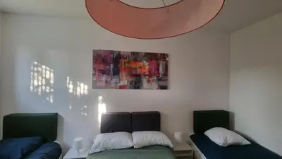 a room with two beds and a painting on the wall at BAM BAM TIBURTINA Guesthouse in Rome