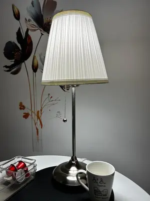 a lamp and a cup on a table with a coffee mug at BAM BAM TIBURTINA Guesthouse in Rome