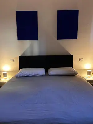 a bedroom with a large bed with two monitors on the wall at BAM BAM TIBURTINA Guesthouse in Rome