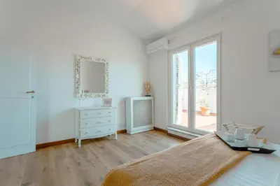 a bedroom with a bed and a dresser and a window at Saint Peter's Luxury Terrace Suites in Rome