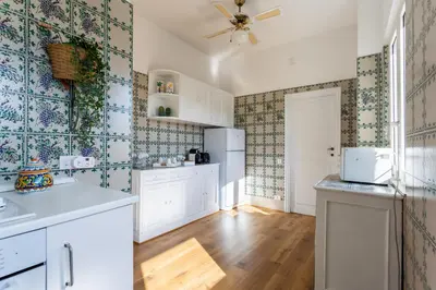 a kitchen with white cabinets and a ceiling fan at Saint Peter's Luxury Terrace Suites in Rome