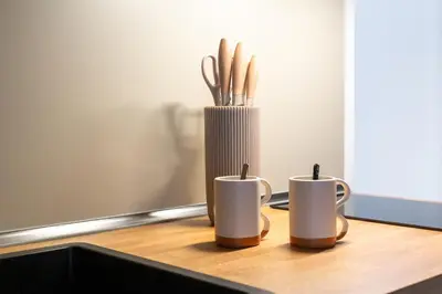 two coffee mugs and a vase on a table at iFlat Modern & Comfortable apt in Trastevere in Rome