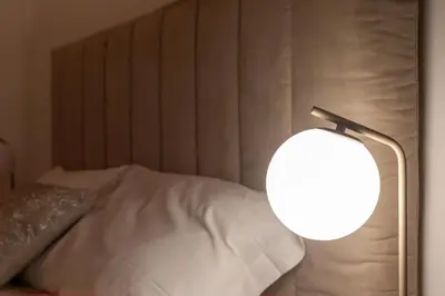 a lamp sitting next to a bed in a room at iFlat Modern & Comfortable apt in Trastevere in Rome