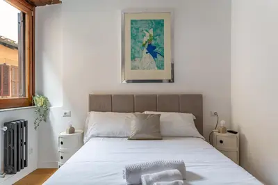 a bedroom with a large bed with white sheets at iFlat Modern & Comfortable apt in Trastevere in Rome