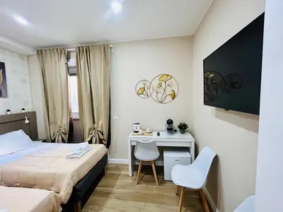 a bedroom with a desk and a bed and a desk and chairs at Segesta Rooms in Rome