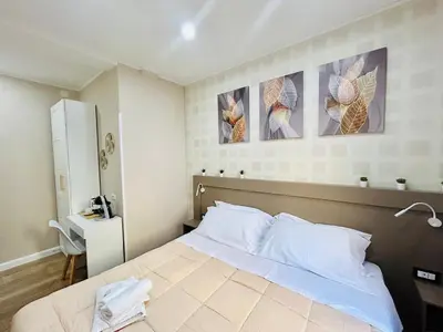 a bedroom with a bed and two paintings on the wall at Segesta Rooms in Rome
