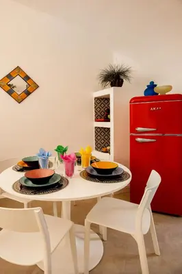 a white table with plates and a red refrigerator at HC - Chez Le Roi Luxury Apartment in Rome