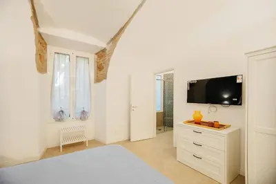 a white room with a tv and a dresser at HC - Chez Le Roi Luxury Apartment in Rome