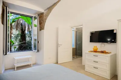 a white bedroom with a tv and a window at HC - Chez Le Roi Luxury Apartment in Rome